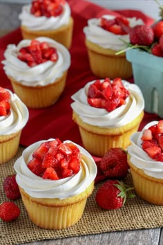 cupcakes with white frosting and strawberries on top