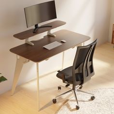 a computer desk with a monitor, keyboard and mouse on it next to a chair