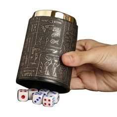 a hand holding a canister with dices in front of it on a white background