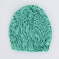 a green knitted beanie on a white background