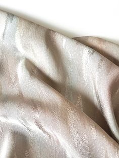 a close up view of a white and silver fabric with wavy lines on it's surface