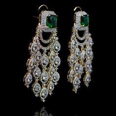 Opt for luxurious modernity! Extravagant chandelier earrings with glimmering CZ stones and an emerald/sapphire accent. Approximate earrings length is 3". Designed over a high quality brass as base metal. Made by order. Kindly allow 4-6 weeks for the delivery of this item. For custom or urgent requests, please contact support@alacouture.com. *Please Note: We use faux stones and beads in all of our jewelry. Luxury Green Diamond Earrings For Wedding, Luxury Chandelier Earrings With Diamond Accents For Party, Luxury Party Chandelier Earrings With Diamond Accents, Luxury Green Chandelier Earrings, Exquisite Cubic Zirconia Chandelier Earrings For Evening, Luxury Hand-set Emerald Earrings, Sparkling Dangle Chandelier Earrings For Formal, Sparkling Dangle Chandelier Earrings For Formal Occasions, Luxury Green Bridal Earrings