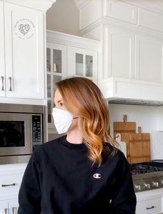 a woman wearing a face mask in the kitchen