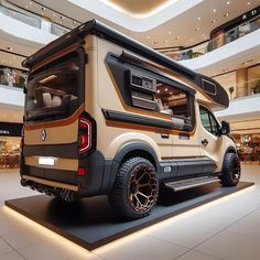 an rv is parked in the middle of a mall with its doors open and it's lights on