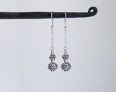 "Oxidized Turkish silver Bali style beads are securely wire wrapped to dangle from sterling silver chain in these fun and flowy earrings. Finished with sterling silver ear wires. Would be lovely dressed up or worn casually. Total length from the top of the ear wires measures about 1 3/4\". Sterling silver is .925 pure silver. Bali silver is .925 pure silver. Turkish silver is .925 pure silver." Sterling Silver Linear Earrings With Dangling Beads For Gift, Silver Wire Wrapped Linear Earrings As Gift, Silver Wire Wrapped Linear Earrings For Gift, Silver Wire-wrapped Sterling Silver Linear Earrings, Silver Wire-wrapped Dangle Linear Earrings, Silver Wire Wrapped Linear Earrings In Sterling Silver, Silver Wire Wrapped Dangle Linear Earrings, Earrings Bali, Bead Dangles