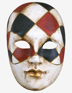 a white mask with red, black and yellow squares on it's face is shown