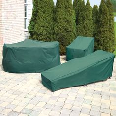 two green couches sitting on top of a brick patio