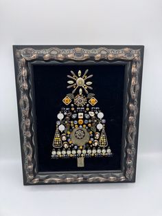 Framed jewelry pieces in black and gold made of vintage bronze earring pieces, vintage bracelet pieces, large rhinestone statement necklace pieces, vintage smokey rhinestone dangle earrings (used in the center of the tree), various rhinestones and metal pieces. Carved wood frame (no easel back, but comes with a gold frame stand). 10 1/2 x 12 1/2 inches. Antique Jeweled Metal Jewelry, Unique Jeweled Jewelry As Gift, Unique Jeweled Jewelry For Gifts, Jeweled Metal Jewelry Gift, Antique Jeweled Jewelry For Gifts, Collectible Costume Jewelry With Jewels, Black Jeweled Jewelry As Gift, Antique Decorative Metal Jewelry, Unique Collectible Jeweled Jewelry