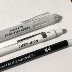 three pens sitting next to each other on top of a table