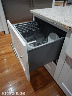 an empty dishwasher in the middle of a kitchen