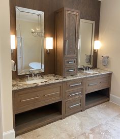 a bathroom with two sinks, mirrors and lights on the wall next to each other