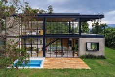 a modern house with a pool in the front yard and large windows on the second floor