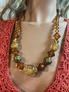 This beautiful necklace is made from resin beads. The colours are brown, beige and gold.  This lovely necklace is 25 inches in length. Vintage Brown Long Necklace As A Gift, Adjustable Brown Vintage Necklace, Vintage Brown Adjustable Necklace, Elegant Amber Beaded Necklaces With Large Beads, Elegant Brown Necklaces With Gold Beads, Elegant Brown Beaded Necklace With Large Beads, Adjustable Brown Necklace With Large Beads, Elegant Brown Necklace With Gold Beads, Gift Long Brown Necklace With Colorful Beads