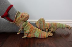 two stuffed animals sitting on the floor next to each other with their legs stretched out