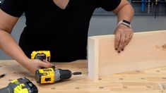 a woman is working on some wood with drillers and screwdrivers next to it