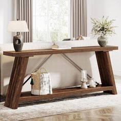 a wooden table sitting in front of a window next to a lamp and vase on top of a rug