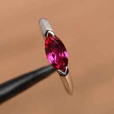 It is a lab ruby ring. The main stone is 5 mm* 10 mm marquise cut.weight about 1.18 carats.The basic metal is sterling silver and plated with rhodium.To change the metal to a solid gold (white/rose) or platinum is also available, please ask for a quotation if you want.You can also go to my shop Home for more elegant rings: https://www.etsy.com/shop/godjewelry?ref=hdr_shop_menu Ruby is July birthstone More ruby rings:https://www.etsy.com/shop/godjewelry?ref=seller-platform-mcnav&section_id=20 Marquise Ruby Ring In White Gold, Marquise White Gold Ruby Ring, White Gold Marquise Ruby Ring, Marquise Ruby Birthstone Ring, Marquise Ruby Promise Ring With Prong Setting, Silver Marquise Ruby Ring, Silver Marquise Cut Ruby Ring, Silver Marquise Cut Ruby Jewelry, Marquise Ruby Ring In Silver