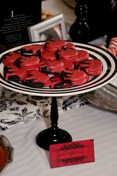 a plate with red cookies on it sitting on a table next to other food items