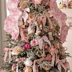 a decorated christmas tree with pink bows and ornaments