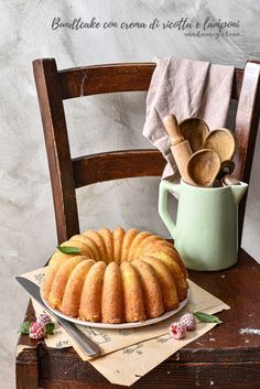 a bundt cake sitting on top of a wooden table next to a green mug