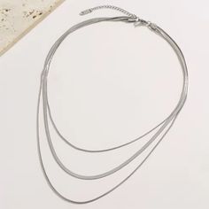 Elevate your style with our Three Strand Gold or Silver Plated Snake Chain Necklace! Featuring a sleek and modern design, this necklace adds a touch of elegance to any outfit. The three strands offer a unique and eye-catching look, while the gold or silver plating adds a luxurious touch. Upgrade your wardrobe with this stunning piece today! Details: - Outer Length 50 + 5cm - Inner Length 42cm - Imported - 18K Gold Plated, Silver Plated Minimalist Multi-strand Metal Layered Necklace, Minimalist Multi-strand Clavicle Chain Necklace, Chic Multi-strand Silver Necklaces, Chic Silver Multi-strand Necklaces, Minimalist Multi-strand Layered Chain Necklace, Minimalist Layered Multi-strand Chain Necklace, Chic Multi-strand Layered Metal Necklace, Chic Multi-strand Layered Necklace, Trendy Silver Multi-strand Layered Necklace