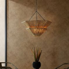 a chandelier hanging from the ceiling over a dining room table with two chairs