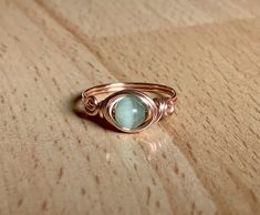 Who doesn't love rose gold? I know I'm in love with it because it's so beautiful and makes unique jewelry looks. This fun ring has a 6mm mint green cat's eye wrapped in 20 gauge rose gold colored wire. The wire is silver plated with a tarnish resistant coating to prevent wear and color change. This ring is simple and dainty with a swirl design on either side of the stone. Cat's eye is a beautiful, man made stone with a brilliant flash that dances in the light. This interesting and eye-catching o Bohemian Rose Gold Ring Jewelry, Bohemian Rose Gold Rings For Gift, Bohemian Rose Gold Rings As Gift, Handmade Oval Rose Gold Rings, Handmade Rose Gold Bohemian Ring, Handmade Bohemian Rose Gold Ring, Wire Wrapped Rose Gold Rings, Rose Gold Boho, Boho Rings Gold