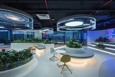 an office with planters and chairs in the center, surrounded by neon lights on the walls