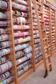 the shelves are full of many different types of thread and spools on them