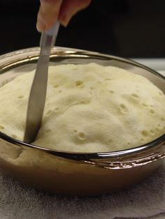 a person is cutting bread in a bowl