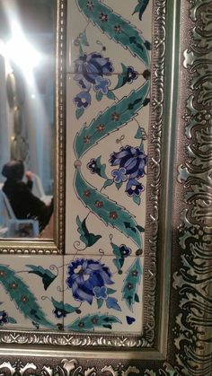 an ornate mirror with blue and white flowers on it