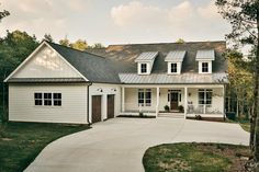 a large white house with lots of windows on it's roof and front porch