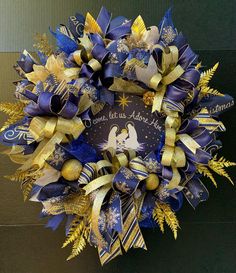 a blue and gold christmas wreath hanging on the front door for someone's home