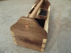 a wooden boat is sitting on the ground with it's seat folded back and open