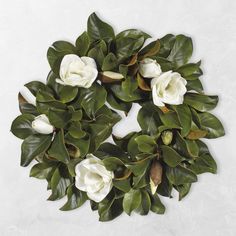 some white flowers and green leaves on a white surface