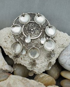 This is the perfect option for those who like cool, unique jewelry, and the luxury, shine of sterling. Vintage Norwegian J 830 Silver Pin Brooch. Composed of filigree circle and 7 cascade of silver filigree with spoons which manages to catch & reflect light beautifully (also reflect negativity & evil) with a simple movement. Is Norway's traditional silver jewelry. Its dangling spoons once were thought to reflect evil. Away from the wearer, protecting one from trolls and other dangers, es Ornate Filigree Pendant Brooch, Handmade Artisan Silver Brooches, Silver Bohemian Brooches For Collectors, Silver Bohemian Brooch Jewelry, Silver Bohemian Jewelry Brooch, Collectible Silver Filigree Brooches, Silver Filigree Brooches For Collectors, Silver Medallion Brooches As A Gift, Silver Brooch With Intricate Design Gift