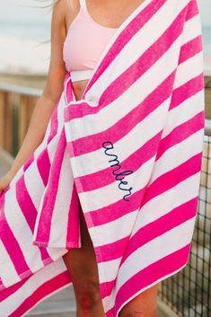 a woman wearing a pink and white striped towel with the word love written on it