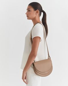 Our sculptural Double Moon Saddle Bag is crafted with practical details of two compartments, a back slip pocket, an easy magnetic closure, and an adjustable strap for crossbody and shoulder carrying. | Made in Turkey from soft and supple leather with a pebbled texture. Our luxurious leather wears well over time and only gets better with age. | Leather Working Group is the world's leading environmental certification for the leather industry. It affirms that our leather is tanned in an environment Modern Top Handle Saddle Bag With Removable Pouch, Modern Crossbody Saddle Bag With Detachable Strap, Modern Saddle Bag With Detachable Strap For Everyday Use, Modern Everyday Saddle Bag With Detachable Strap, Chic Crossbody Saddle Bag For Travel, Modern Saddle Shoulder Bag With Detachable Handle, Luxury Crossbody Saddle Bag For Everyday, Luxury Everyday Crossbody Saddle Bag, Chic Travel Saddle Bag