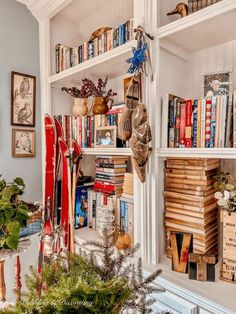 Cozy corner book nook with sheepskin chair, side table plants, and hanging decorative wood spindles on bookshelving.