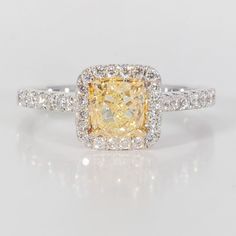 a fancy yellow diamond ring with diamonds around it