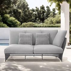 a couch sitting on top of a white floor next to a wall with trees in the background