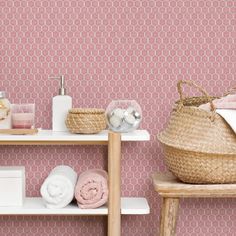 a shelf with towels, soaps and other items on it in front of a pink wall