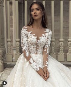 a woman in a white wedding dress sitting on the steps with her hand on her hip