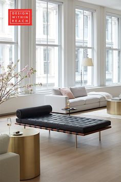 a living room filled with lots of windows next to a white couch and coffee table