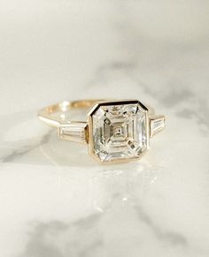 an engagement ring with two baguets on the side and a diamond in the middle