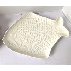 a white fish shaped dish next to a bowl