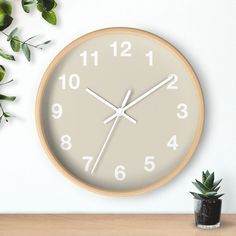 a clock on the wall next to a potted plant