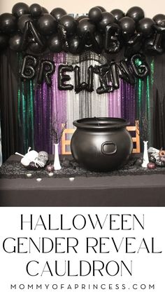 halloween gender reveal with black balloons and witch's cauldron on the table