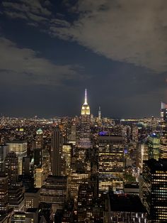 the city skyline is lit up at night, with skyscrapers in the foreground