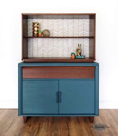 a blue cabinet sitting on top of a hard wood floor next to a white wall